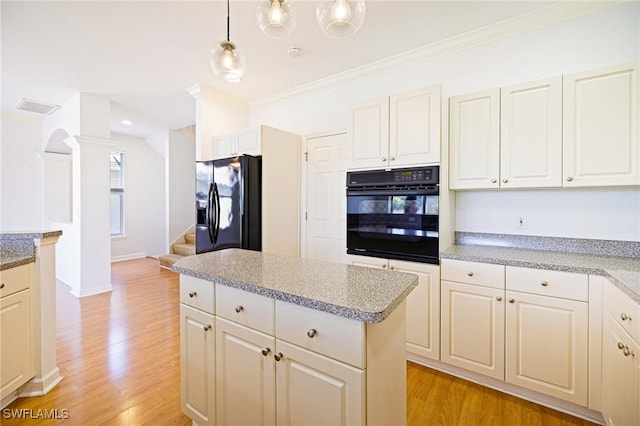 6081 Waterway Bay Dr, Fort Myers, FL 33908 - kitchen with light wood finished floors, pendant lighting, black appliances, and crown molding