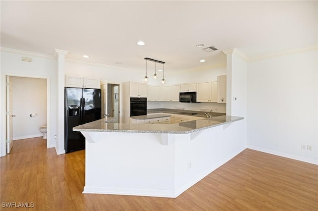 6081 Waterway Bay Dr, Fort Myers, FL 33908 - kitchen featuring a peninsula, visible vents, crown molding, and black appliances