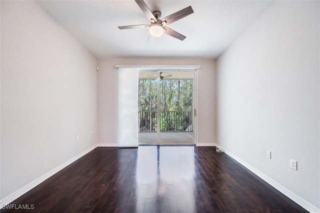 spare room with dark wood-style flooring, a ceiling fan, and baseboards