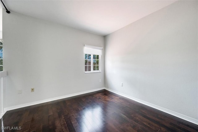 unfurnished room featuring dark wood-style flooring and baseboards