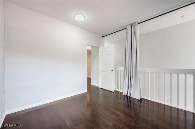 unfurnished bedroom featuring wood finished floors and baseboards