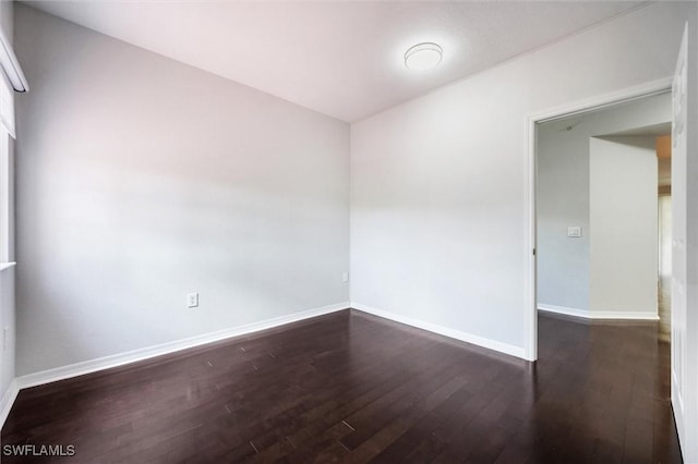 spare room featuring hardwood / wood-style floors and baseboards