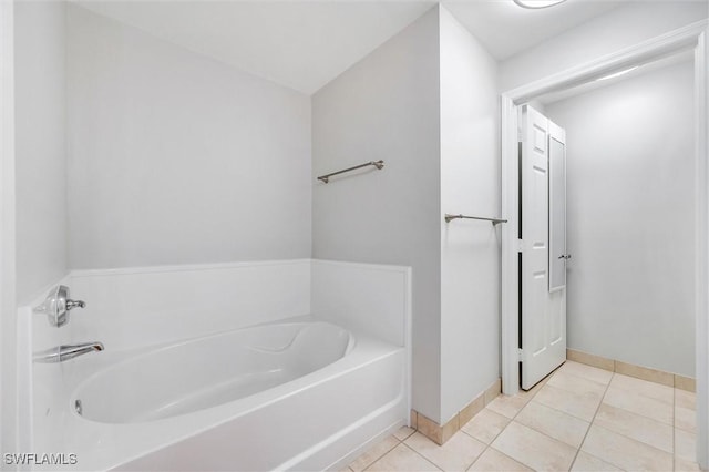 bathroom with tile patterned floors, a garden tub, and baseboards