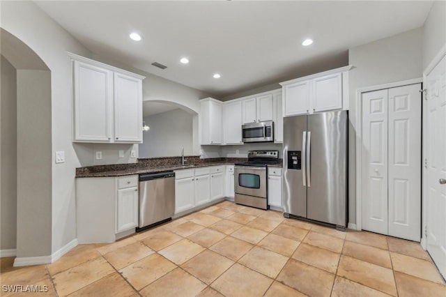 17577 Cherry Ridge Ln, Fort Myers, FL 33967 - kitchen with visible vents, white cabinetry, arched walkways, and stainless steel appliances