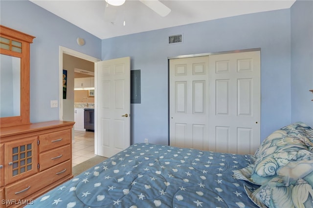 bedroom featuring a closet, a ceiling fan, tile patterned flooring, visible vents, and a sink