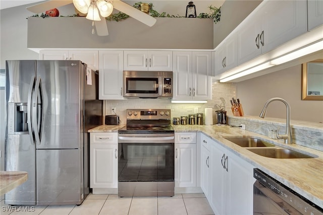 kitchen featuring a ceiling fan, white cabinets, light tile patterned flooring, a sink, and stainless steel appliances