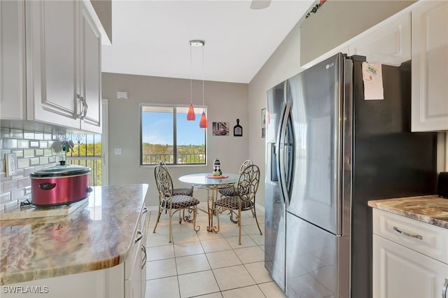 kitchen with stainless steel fridge with ice dispenser, baseboards, vaulted ceiling, white cabinetry, and decorative backsplash