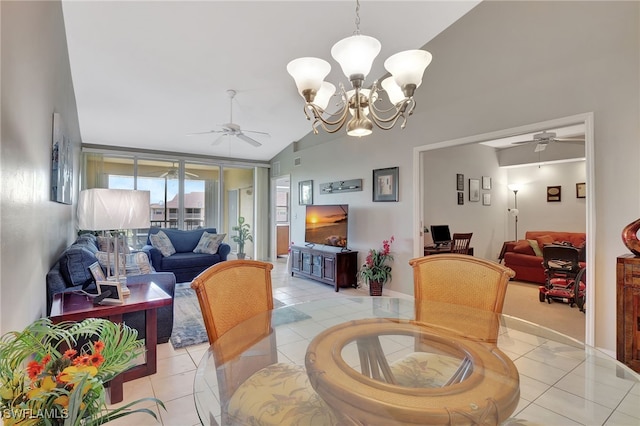 dining space with ceiling fan with notable chandelier, light tile patterned floors, and high vaulted ceiling