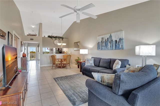 living area featuring high vaulted ceiling, ceiling fan with notable chandelier, baseboards, and light tile patterned flooring