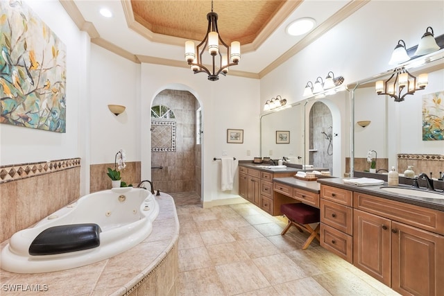 bathroom featuring a tray ceiling, a tub with jets, a chandelier, a sink, and walk in shower