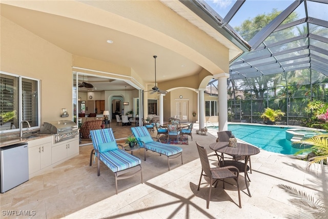 view of patio with ceiling fan, a pool with connected hot tub, exterior kitchen, grilling area, and outdoor dining area