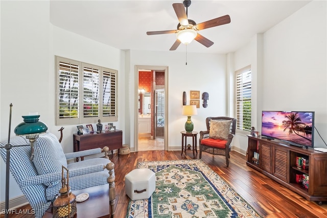 living area featuring ceiling fan, baseboards, and wood finished floors