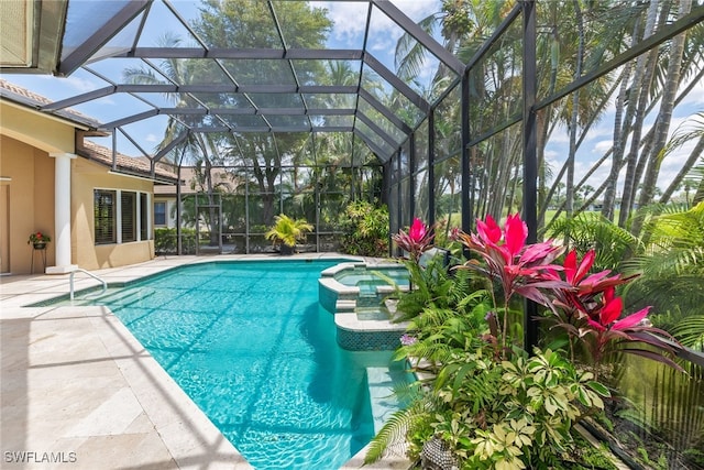 view of pool featuring a pool with connected hot tub, a patio, and glass enclosure
