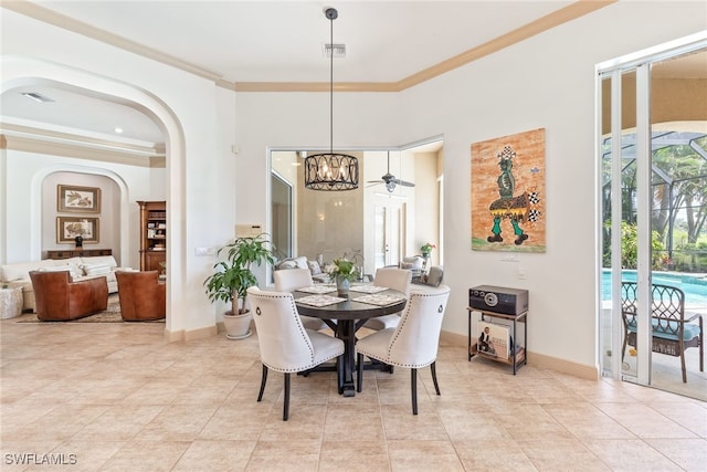 dining area featuring a chandelier, light tile patterned floors, crown molding, visible vents, and arched walkways