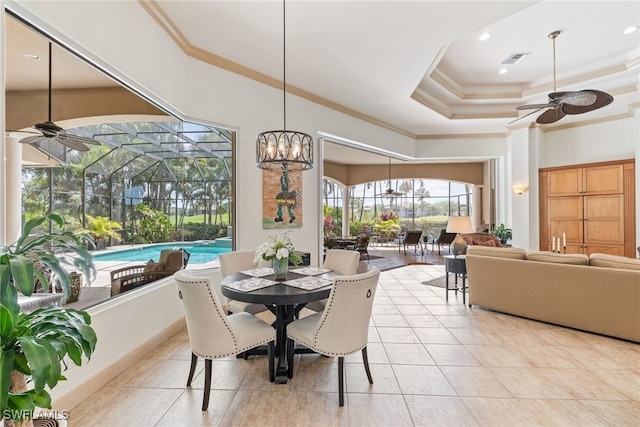 dining space featuring visible vents, a tray ceiling, a ceiling fan, and ornamental molding