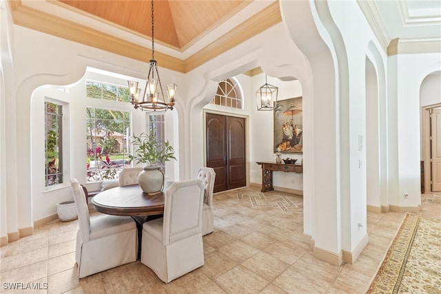 dining space with a chandelier, arched walkways, a high ceiling, and ornamental molding
