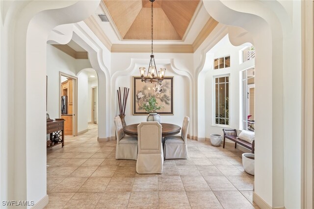 dining space featuring an inviting chandelier, a tray ceiling, arched walkways, ornamental molding, and visible vents