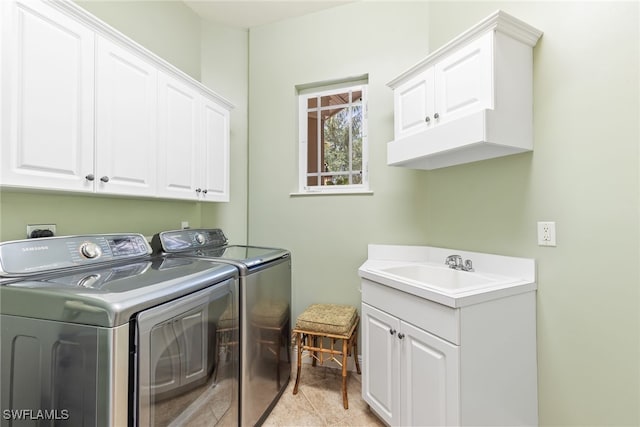laundry room featuring washing machine and dryer, a sink, and cabinet space