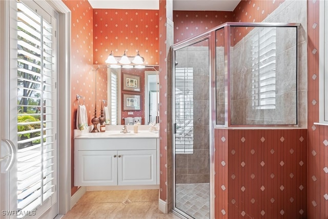 full bathroom featuring tile patterned flooring, vanity, wallpapered walls, and a stall shower