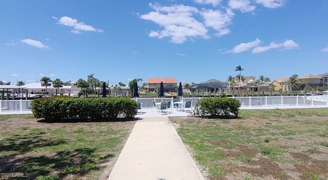 view of home's community with a yard, fence, and a residential view