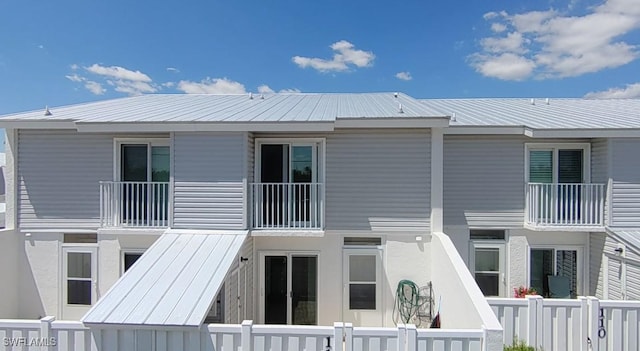 rear view of house featuring metal roof and fence private yard
