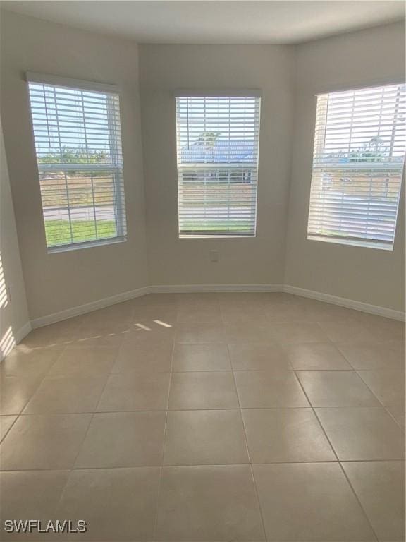 211 NE 20th St, Cape Coral, FL 33909 - unfurnished room with baseboards, light tile patterned flooring, and a healthy amount of sunlight