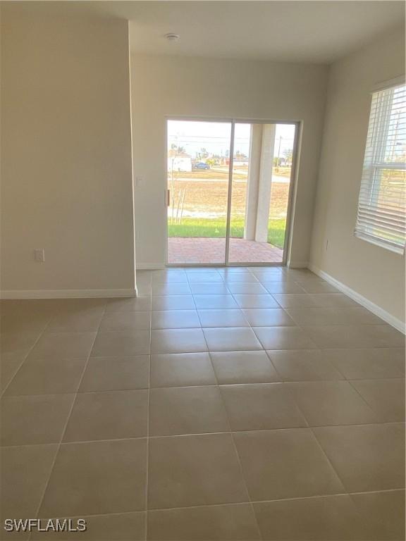 211 NE 20th St, Cape Coral, FL 33909 - unfurnished room featuring a healthy amount of sunlight, light tile patterned flooring, and baseboards