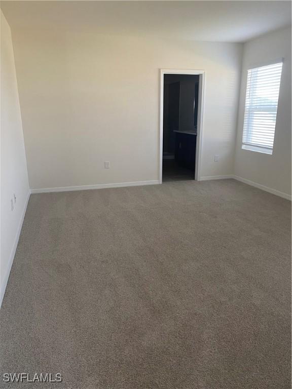 211 NE 20th St, Cape Coral, FL 33909 - carpeted empty room with baseboards