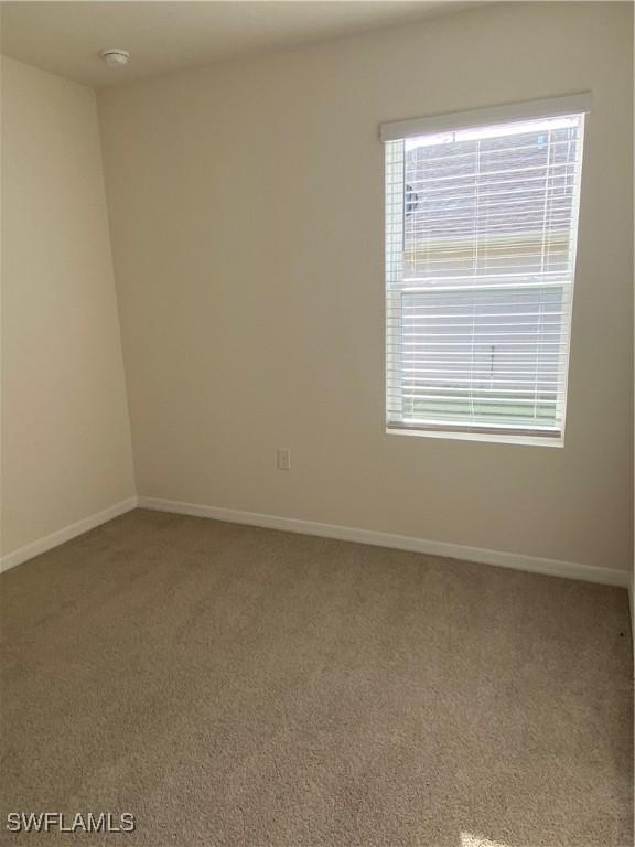 211 NE 20th St, Cape Coral, FL 33909 - carpeted spare room with a healthy amount of sunlight and baseboards
