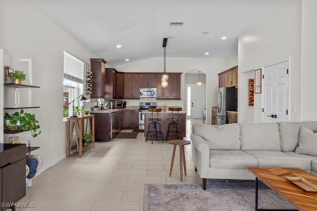 living room with healthy amount of natural light, arched walkways, vaulted ceiling, and baseboards