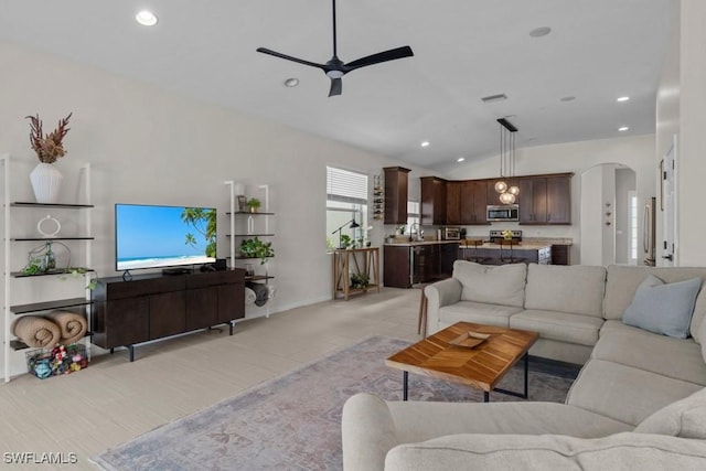 living area with a ceiling fan, lofted ceiling, recessed lighting, and arched walkways