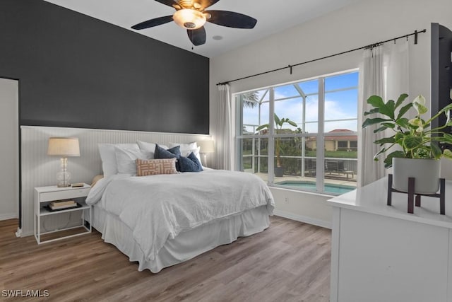 bedroom featuring wood finished floors, baseboards, and a ceiling fan