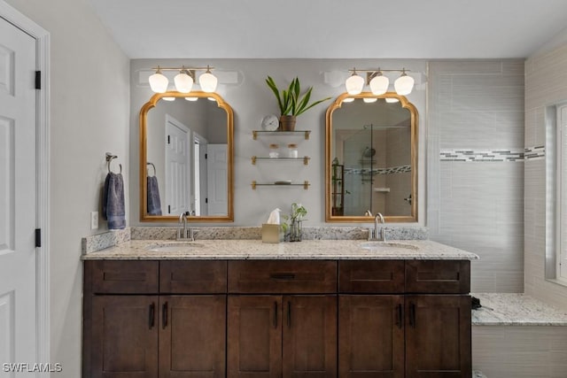 full bath featuring tiled shower and double vanity
