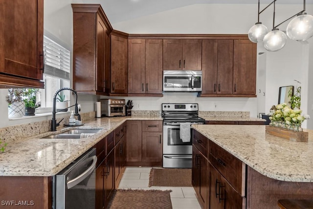 kitchen with stainless steel appliances, a sink, vaulted ceiling, light stone counters, and light tile patterned flooring