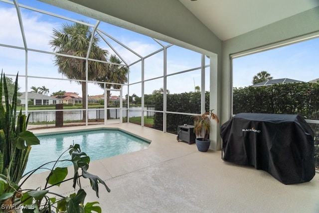 view of swimming pool featuring a patio, a water view, glass enclosure, grilling area, and fence