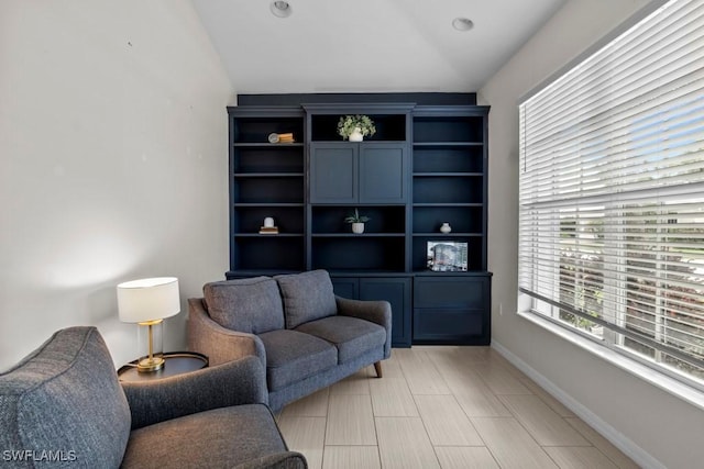 sitting room with vaulted ceiling and baseboards