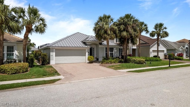 ranch-style house featuring stucco siding, decorative driveway, a garage, and a front lawn