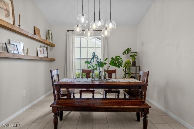 dining space featuring a chandelier and baseboards
