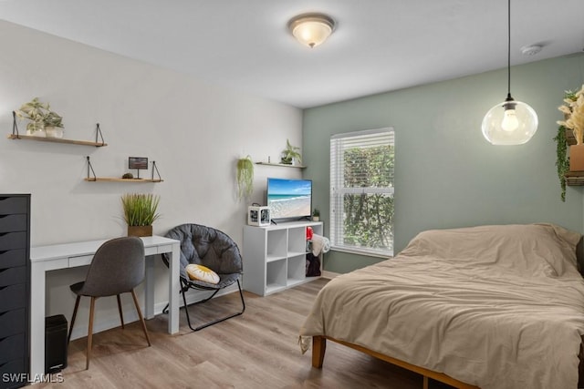 bedroom with a desk, wood finished floors, and baseboards