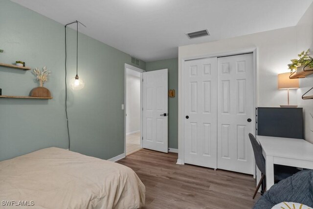 bedroom featuring wood finished floors, a closet, and baseboards