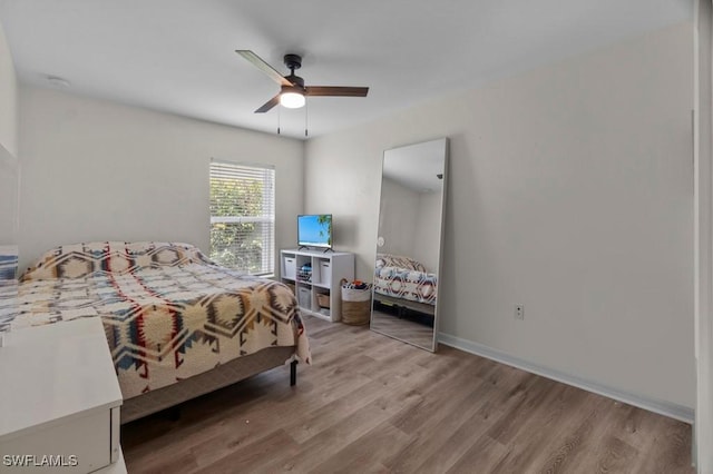 bedroom with wood finished floors, a ceiling fan, and baseboards