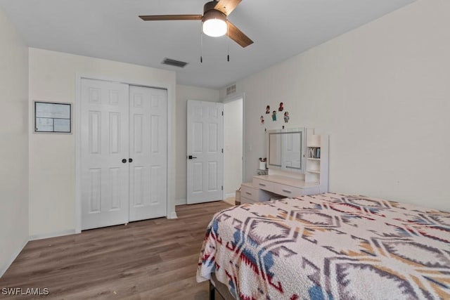 bedroom with wood finished floors, a closet, a ceiling fan, and baseboards