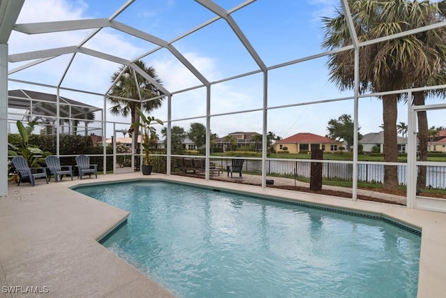 view of swimming pool with a patio area, a residential view, a water view, and a lanai