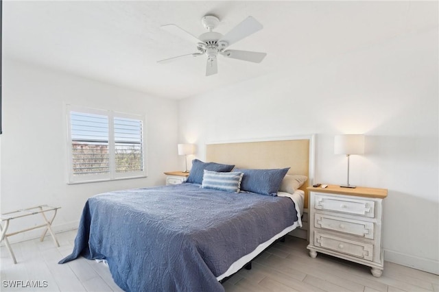 bedroom featuring baseboards, wood finished floors, and a ceiling fan
