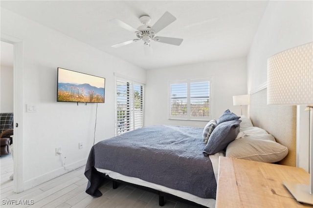 bedroom featuring light wood finished floors, baseboards, and ceiling fan