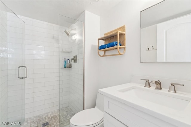 full bathroom featuring a stall shower, toilet, and vanity