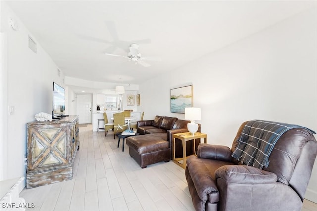 living area featuring a ceiling fan and light wood-style flooring