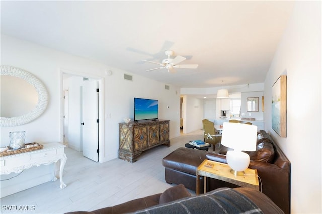 living room with a ceiling fan and light wood-style floors