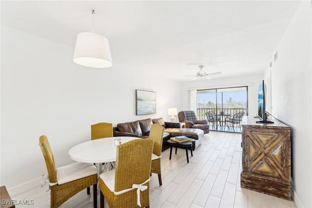 dining area with ceiling fan and light wood-style floors