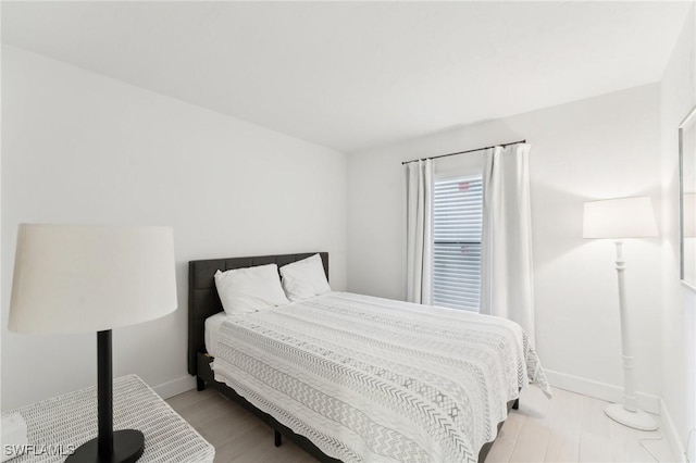 bedroom with baseboards and light wood-style flooring